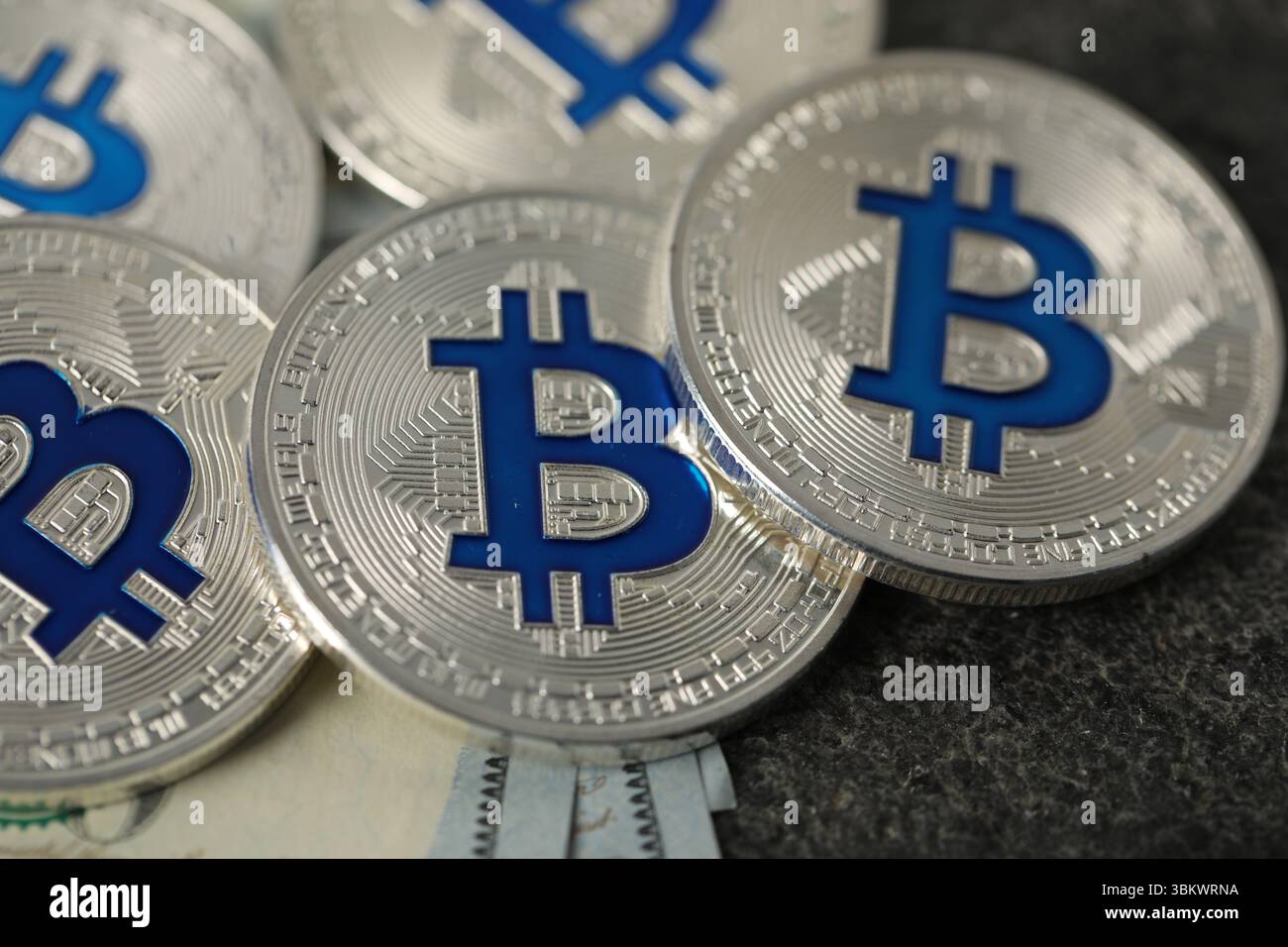 Kryptowährung. Bitcoins und Dollarscheine auf grauem Tisch, Nahaufnahme Stockfoto