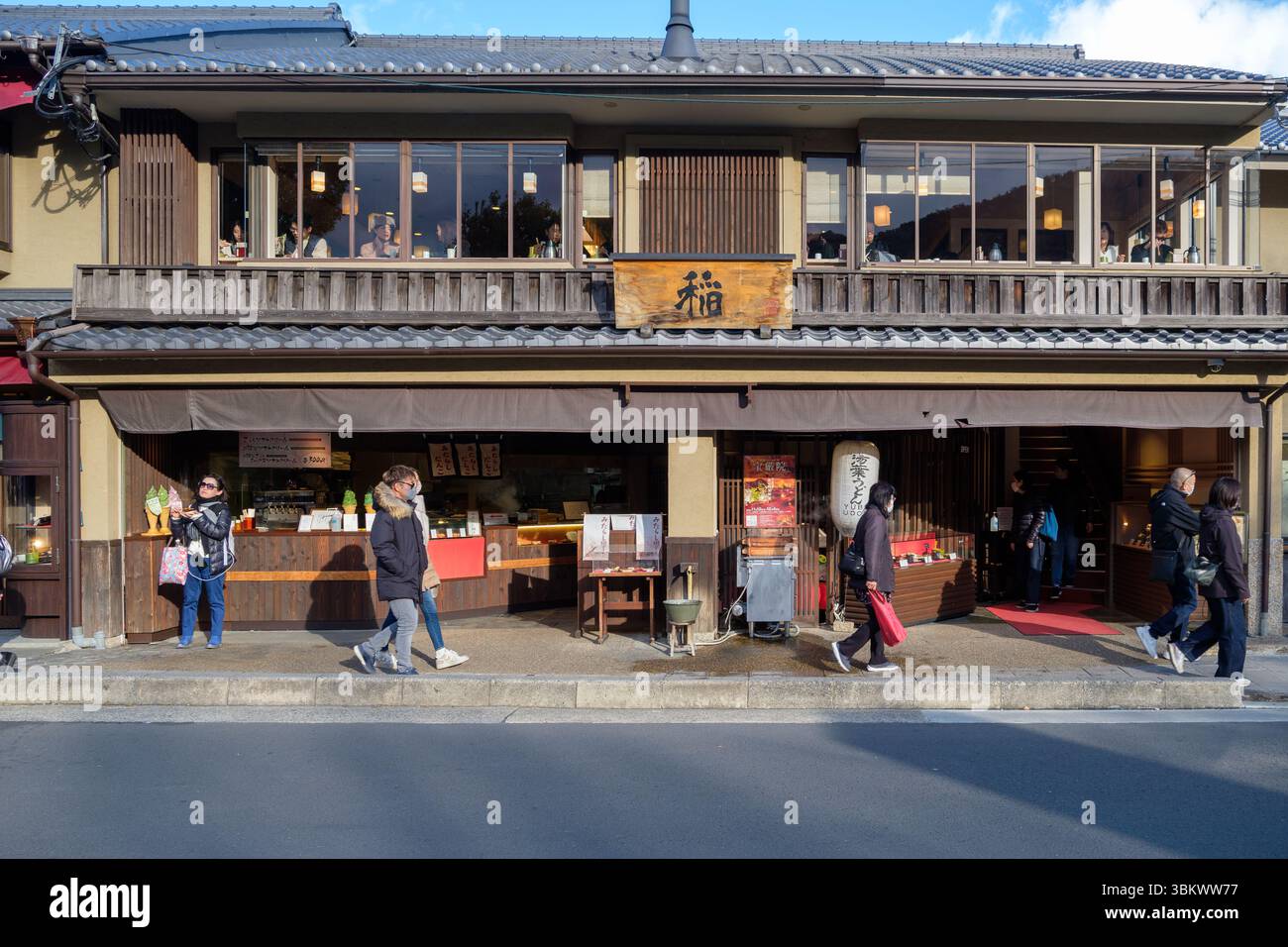 Straßenszene in Japan mit Spaziergängen, Einkaufen für Snacks wie Danco und Eis und Abendessen in einem Restaurant. Stockfoto