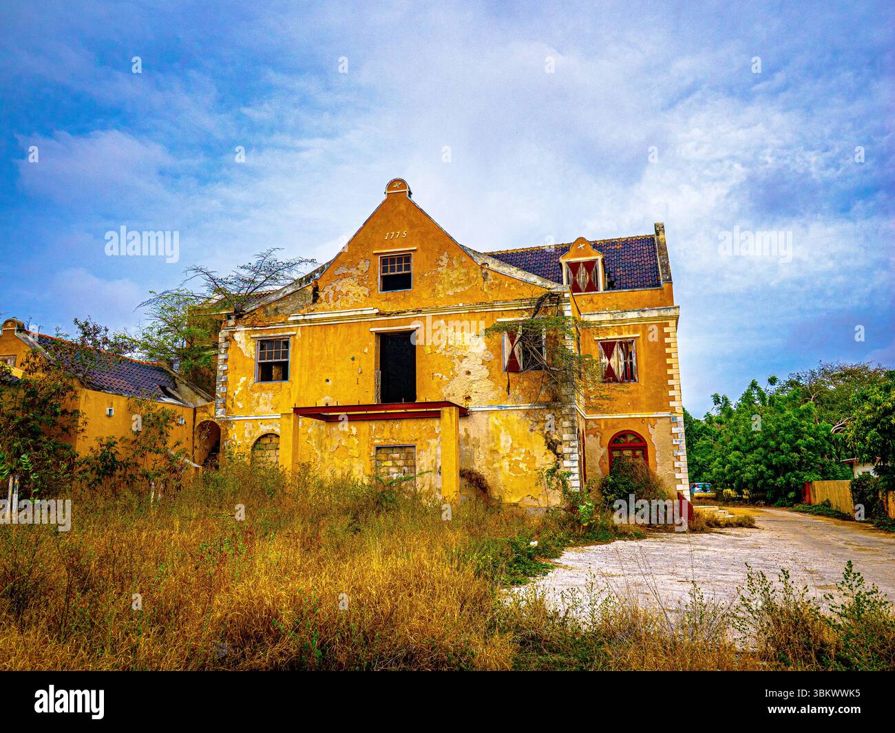 Verlassenes, verwittertes Gebäude in der Karibik, umgeben von tropischer Vegetation, mit Verfall und rustikalem Charme in abgelegener Umgebung. Stockfoto