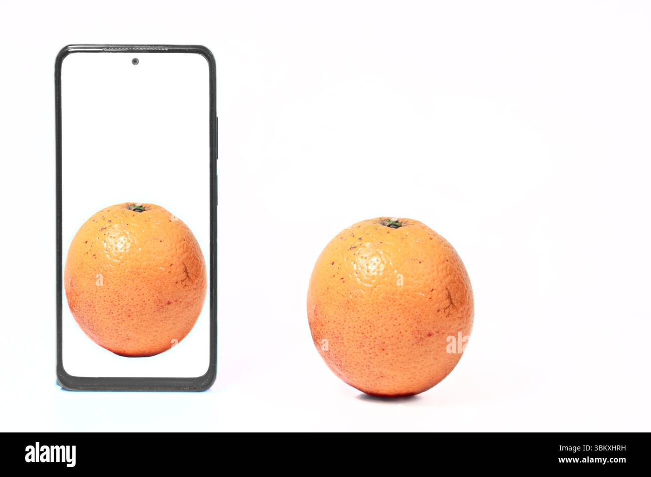 Orange und Handy, konzeptionelles Foto. Stockfoto