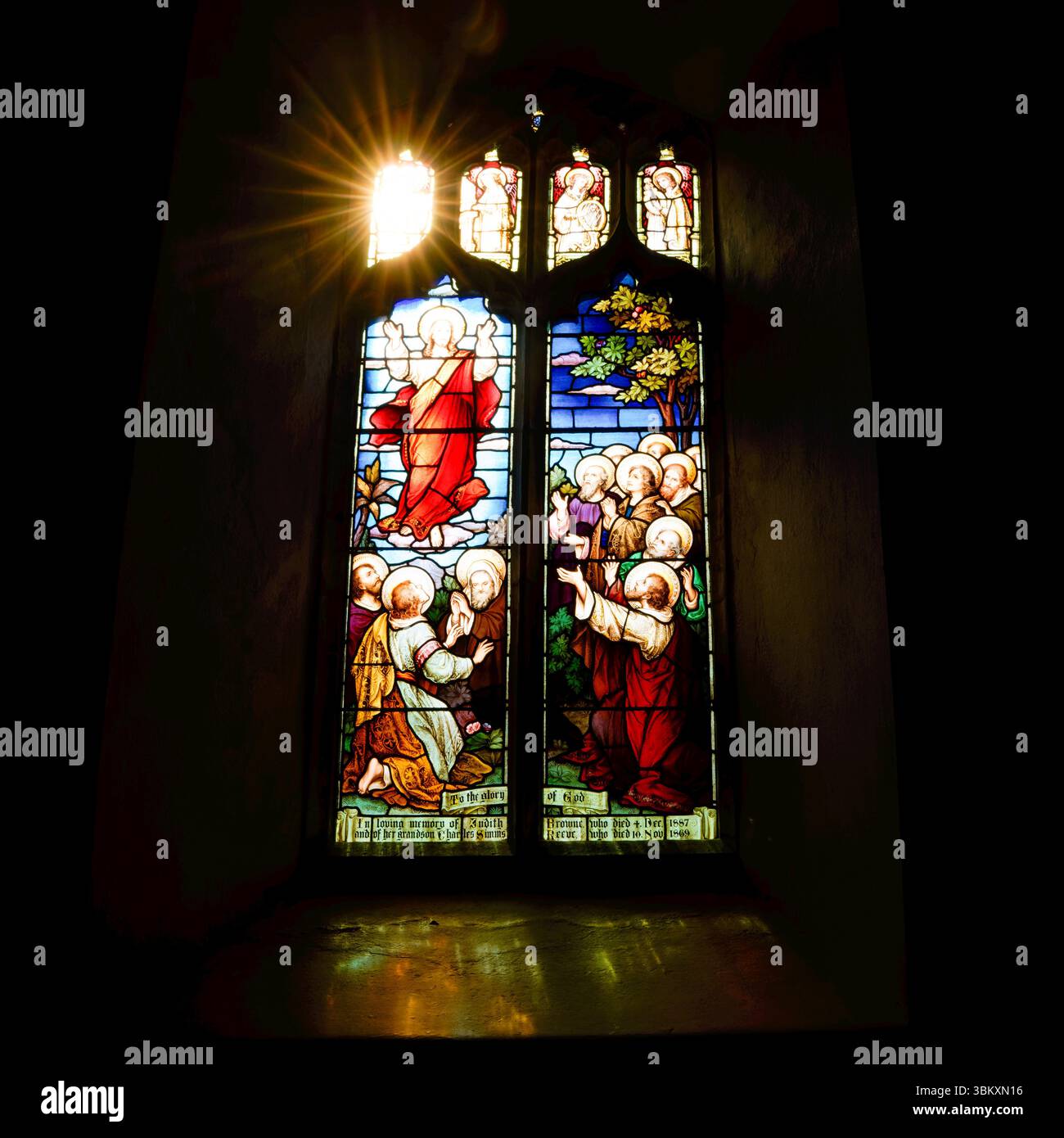 Der Sonnenschein leuchtet durch die Kirchenfenster aus Buntglas in St. Mary's Church, Tichwell, Norfolk, Großbritannien Stockfoto
