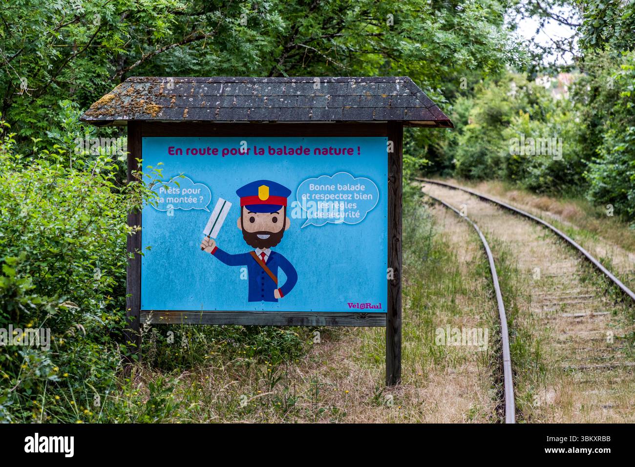 Eine Vélorail-Informationstafel auf der Route in der Nähe von Chauvigny (Nouvelle-Aquitaine, Frankreich) mit der Aufschrift „EN Route pour la Balade Nature!“ – Eine zweisprachige Illustration mit Sicherheitshinweisen und der Figur eines Leiters der Betreibergesellschaft Vélorail. Velorail ist eine Art von Fahrradbahn, die für Touren an verschiedenen Orten in Frankreich genutzt werden kann. Avenue de la Vienne, Chauvigny, Nouvelle-Aquitaine, Frankreich Stockfoto