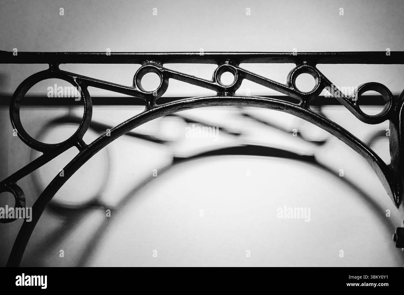 Schwarzes Gusseisen, symmetrisch gemusterte Struktur mit dunklen Schatten auf weißem Hintergrund Stockfoto