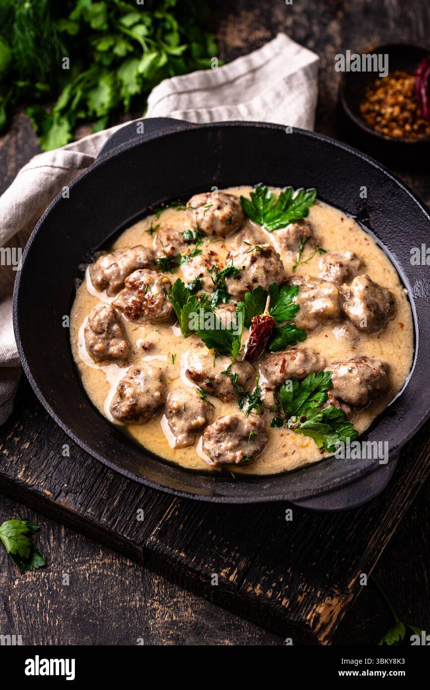 Fleischbällchen in Sauerrahmsauce in einer Pfanne Stockfoto