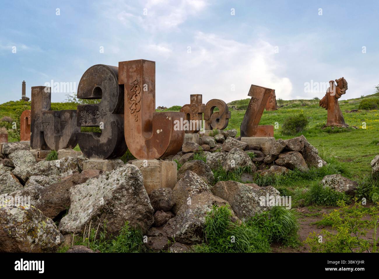 Riesige Steinbriefe, die das einzigartige Drehbuch der Nation feiern, stehen vor der dramatischen Kulisse des Mount Aragats am Armenian Alphabet Monument. Stockfoto