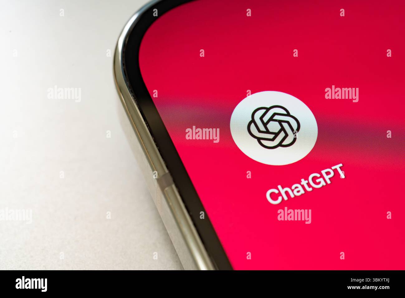 Nahaufnahme eines Smartphones mit dem Symbol der ChatGPT-App mit rotem Hintergrund, das für moderne KI-Technologie steht. Stafford, Vereinigtes Königreich, 23. Juni, Stockfoto
