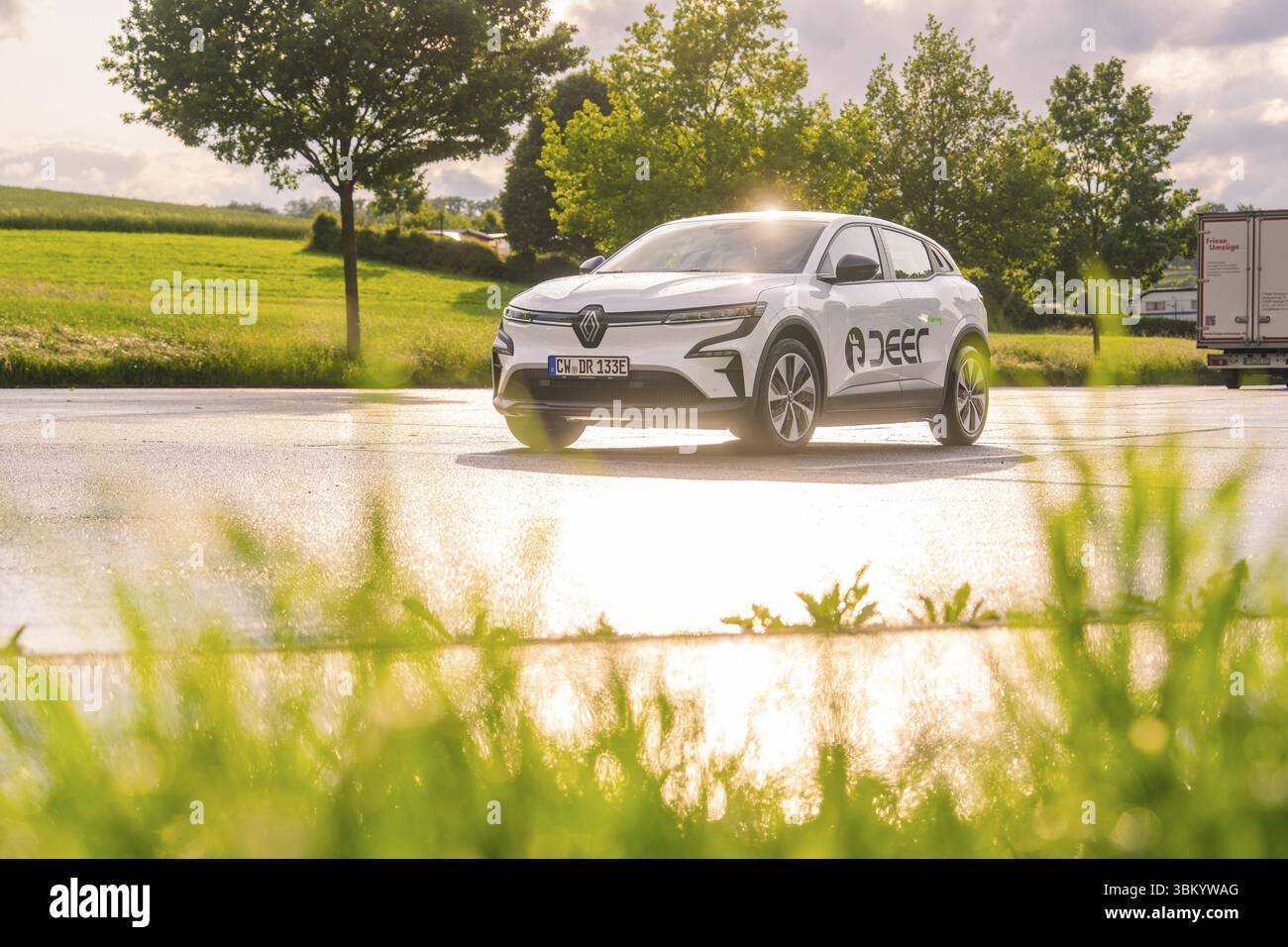 Auto fährt über eine nasse Straße, umgeben von grüner Natur und Bäumen, Hirsch E-Carsharing, Renault Megane Elektroauto, Calw, Schwarzwald, Deutschland, Europ Stockfoto