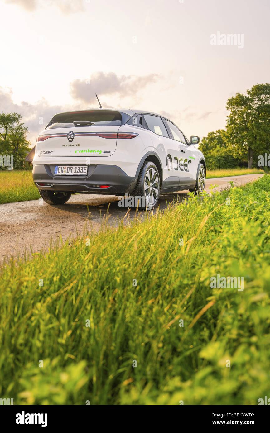 Rückansicht eines Renault auf einer Landstraße umgeben von Wiesen, Hirsch E-Carsharing, Renault Megane Elektroauto, Calw, Schwarzwald, Deutschland, Europa Stockfoto