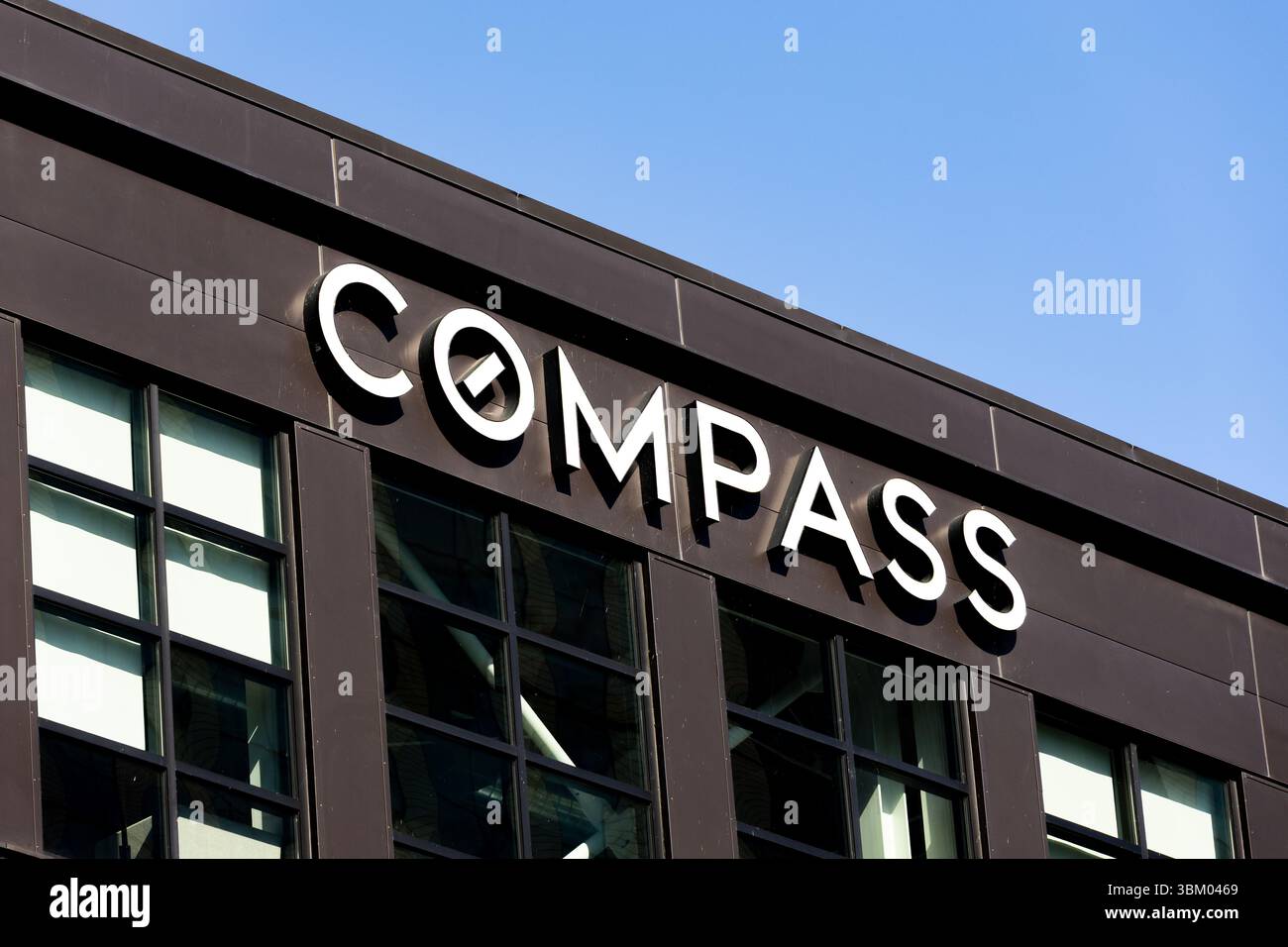 Das Compass Real Estate Logo auf einem Backsteingebäude in der Innenstadt von Seattle, WA. Stockfoto