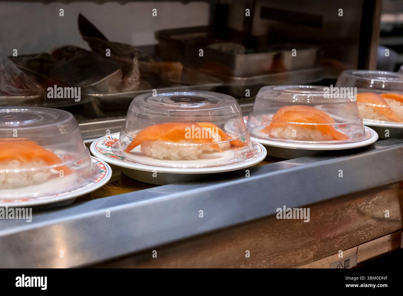 Lachs-Sushi auf Förderband im Restaurant, Tsukiji Market, Tokio, Japan Stockfoto