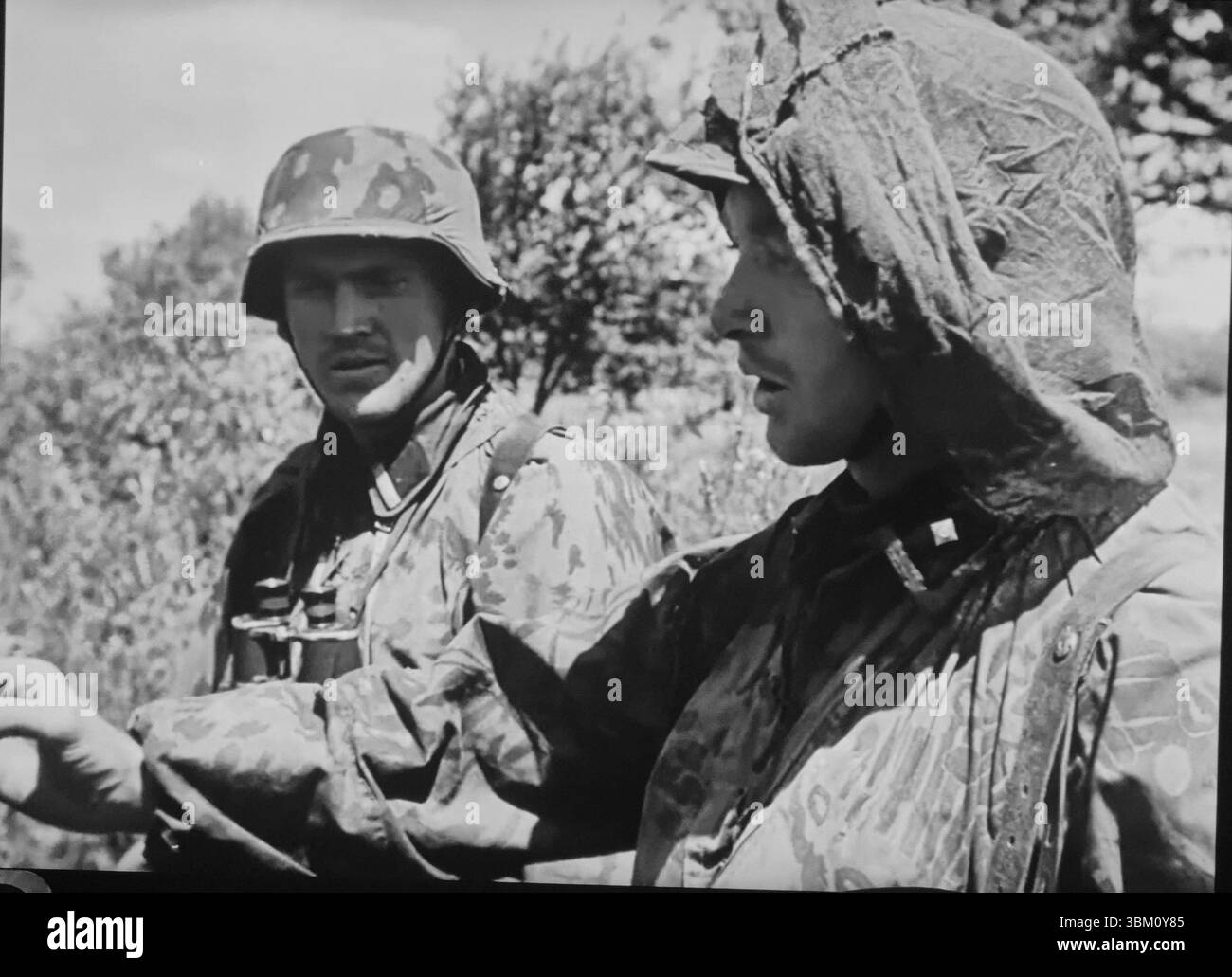 WW2 Screen B&W noch deutsche Waffen-SS-Soldaten in Camo Smocks und einer hat Insektenschutznetz an der russischen Front Stockfoto