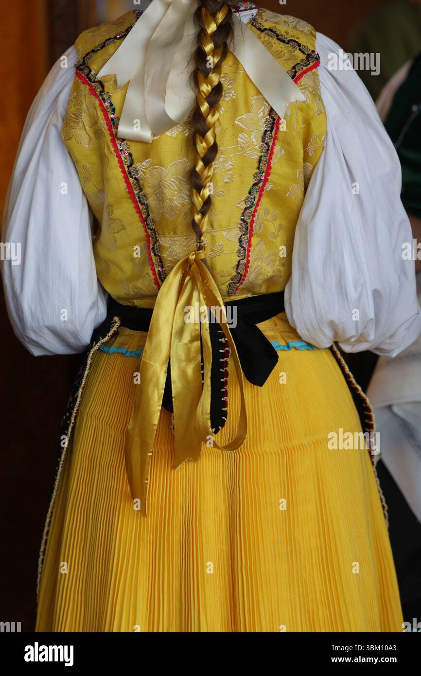 Traditionelle gelbe slowakische oder tschechische Volkstracht mit geflochtenem Band Stockfoto