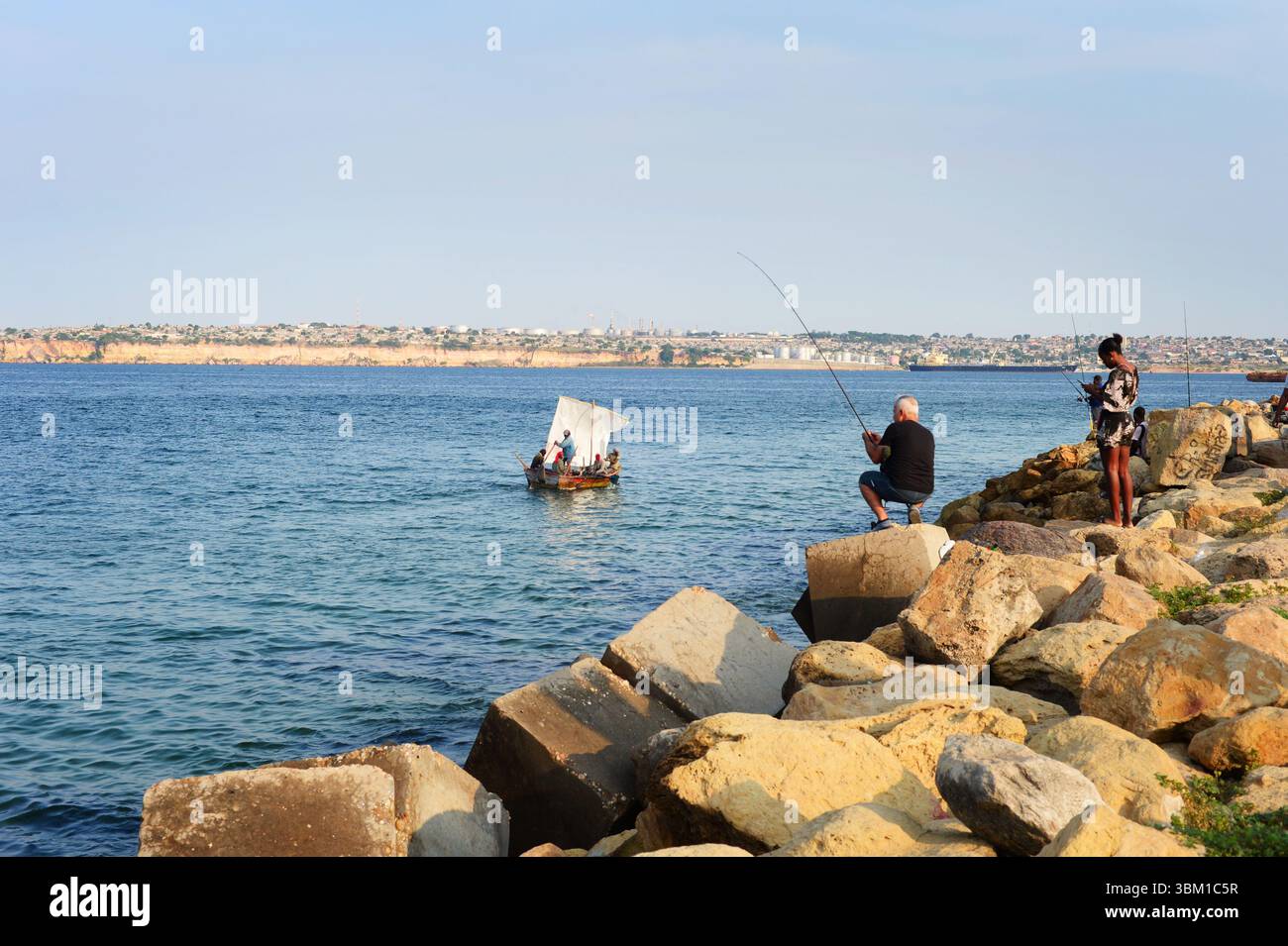 LUANDA, ANGOLA - 3. Februar 2025: Menschen auf einem Holzsegel im Meer bei Ilha de Luanda. Luanda, Angola Stockfoto