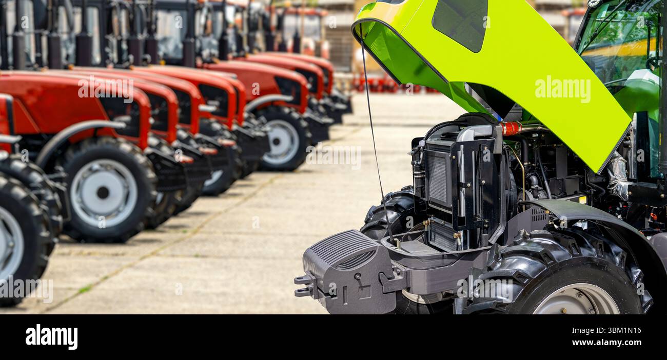 Traktor mit offener Motorhaube am Los des Händlerbetriebs für landwirtschaftliche Geräte Stockfoto