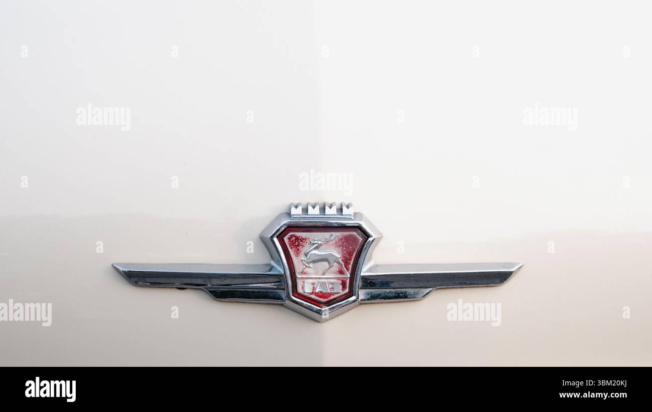 Jekaterinburg, Russland: 8. Juni 2025: Das ikonische Frontemblem eines Oldtimer-GAZ mit rotem Abzeichen mit silbernem Hirsch und kyrillischem Text, Stockfoto