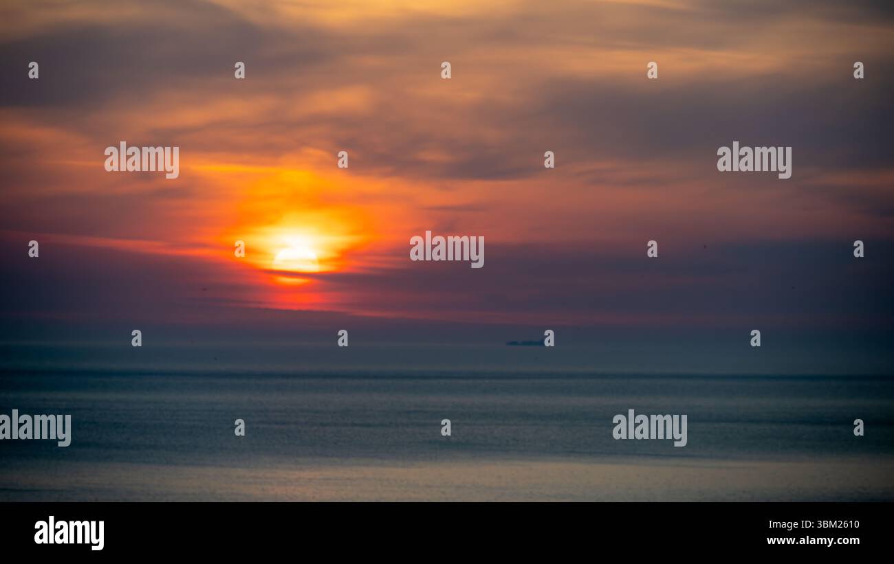 Sonnenaufgang über dem Meer mit Wolken und Mustern. Stockfoto