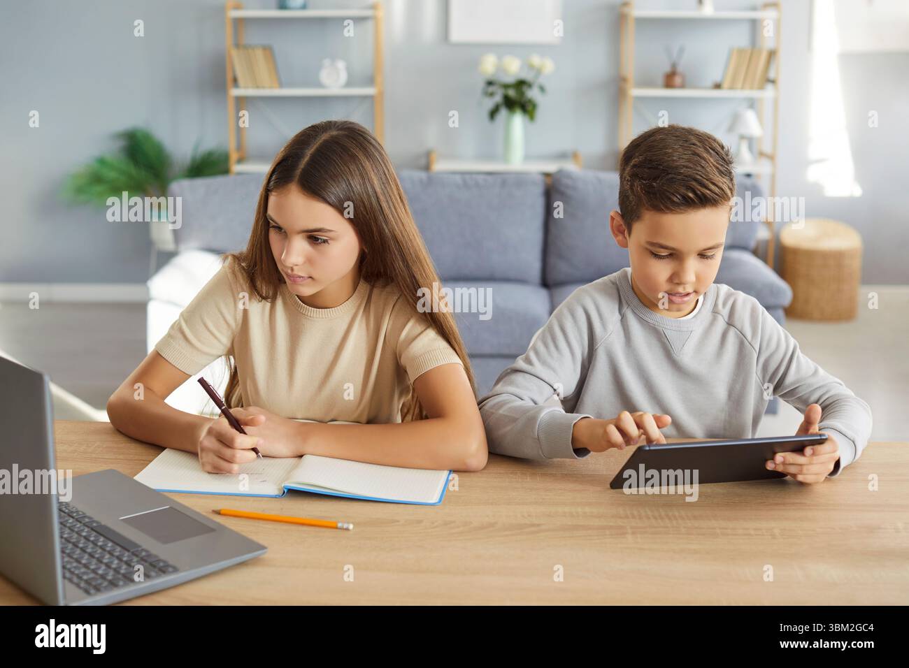 Bruder und Schwester lernen zu Hause zusammen, machen Hausaufgaben Stockfoto
