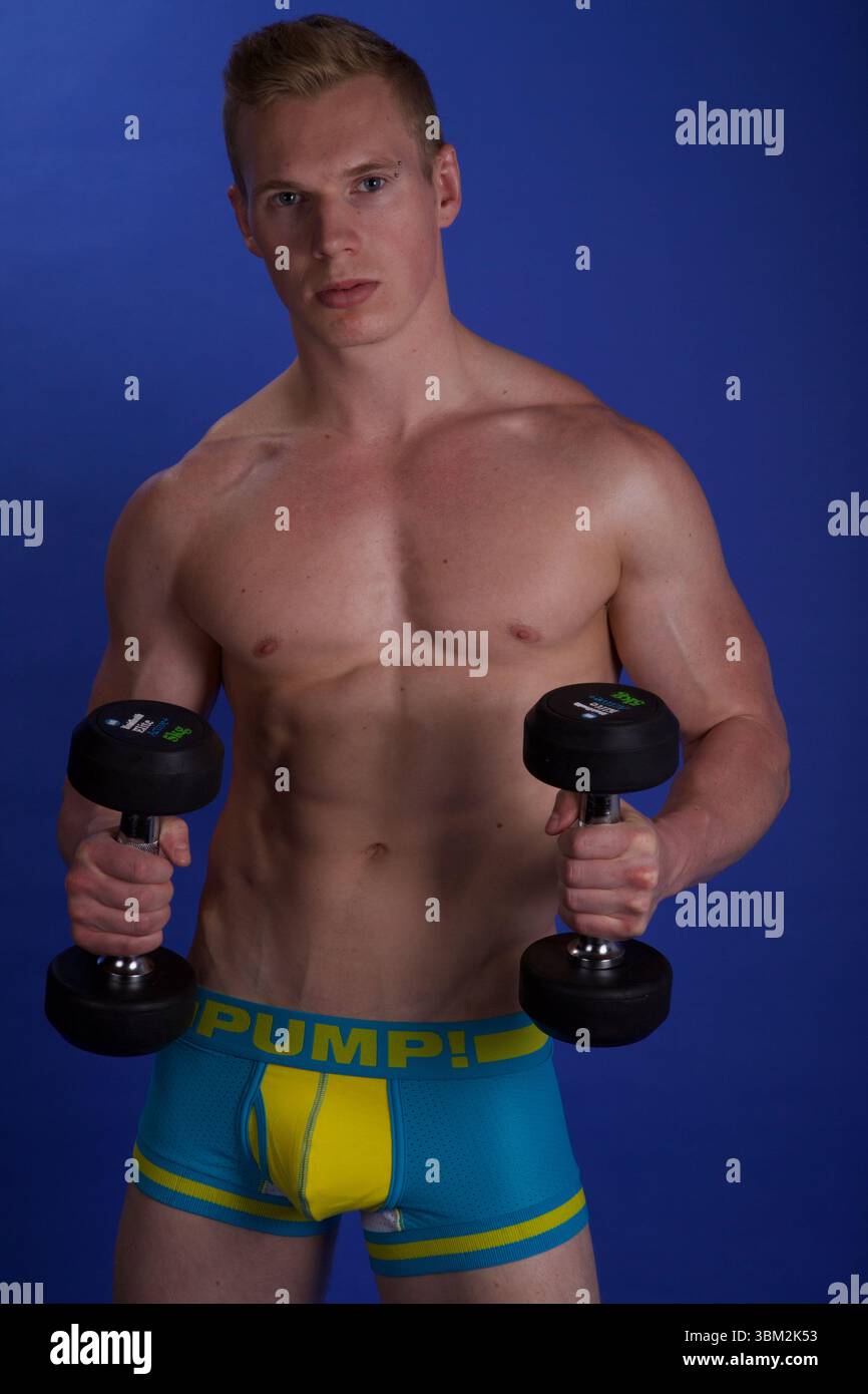 Ein Mann, der eine Hammerlocke mit einem Paar Kurzhanteln durchführt Stockfoto