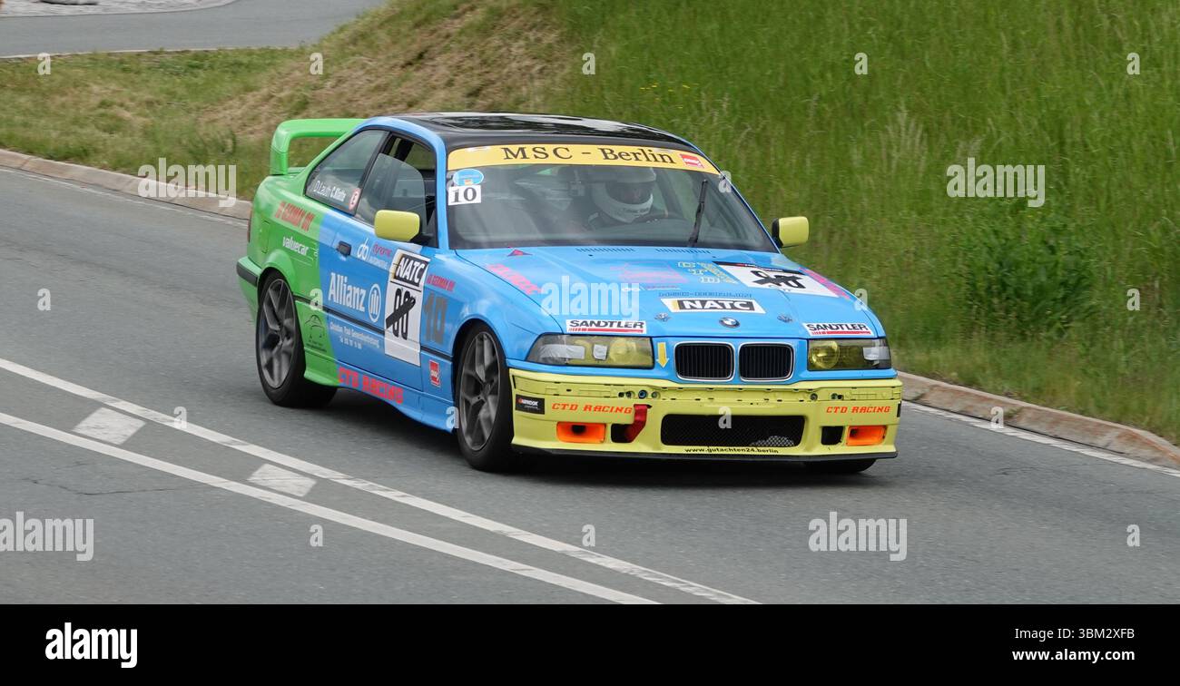 Farbenfrohe BMW Tourenwagen-Rennen in der ADMV Classic Serie in Deutschland. Klassische Motorsportszene mit modifiziertem BMW auf einem geschlossenen Rundkurs. Stockfoto
