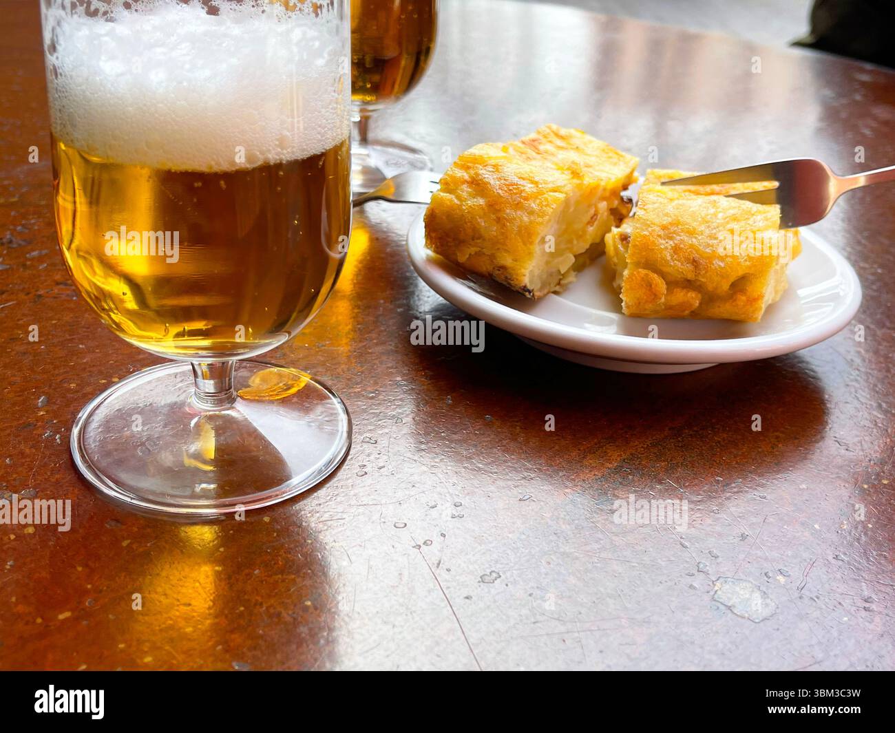 Ein Glas Bier mit spanischem Omelett auf der Terrasse. Spanien. - Smartphone-aufgenommenes Stockfoto