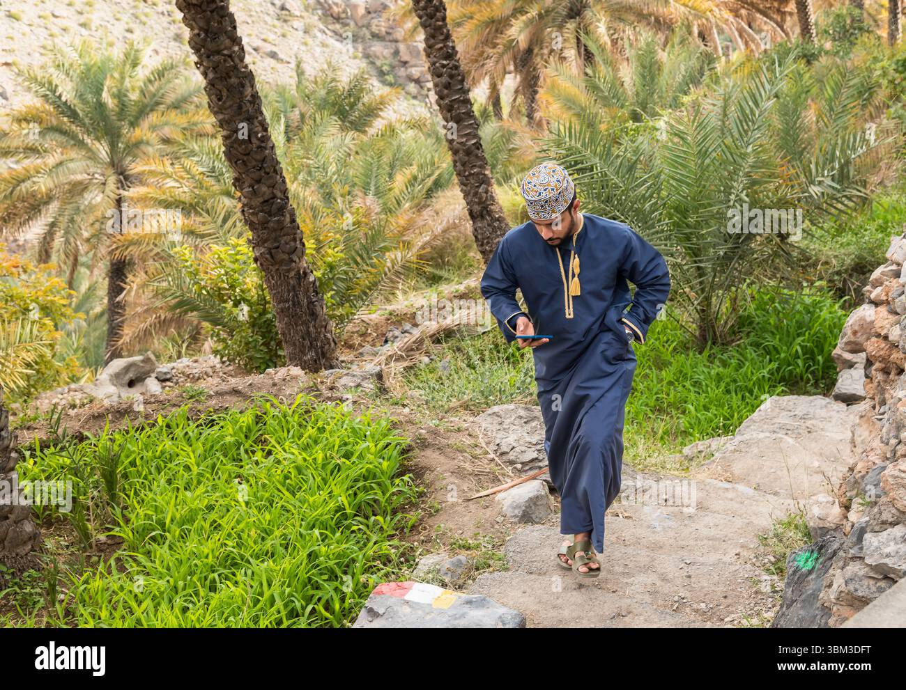 Misfat Al Abriyeen, Oman - 11. Februar 2020: Porträt eines lächelnden omanischen Mannes in traditionellem blauem Dschadscha und besticktem omanischen Kuma. Stockfoto