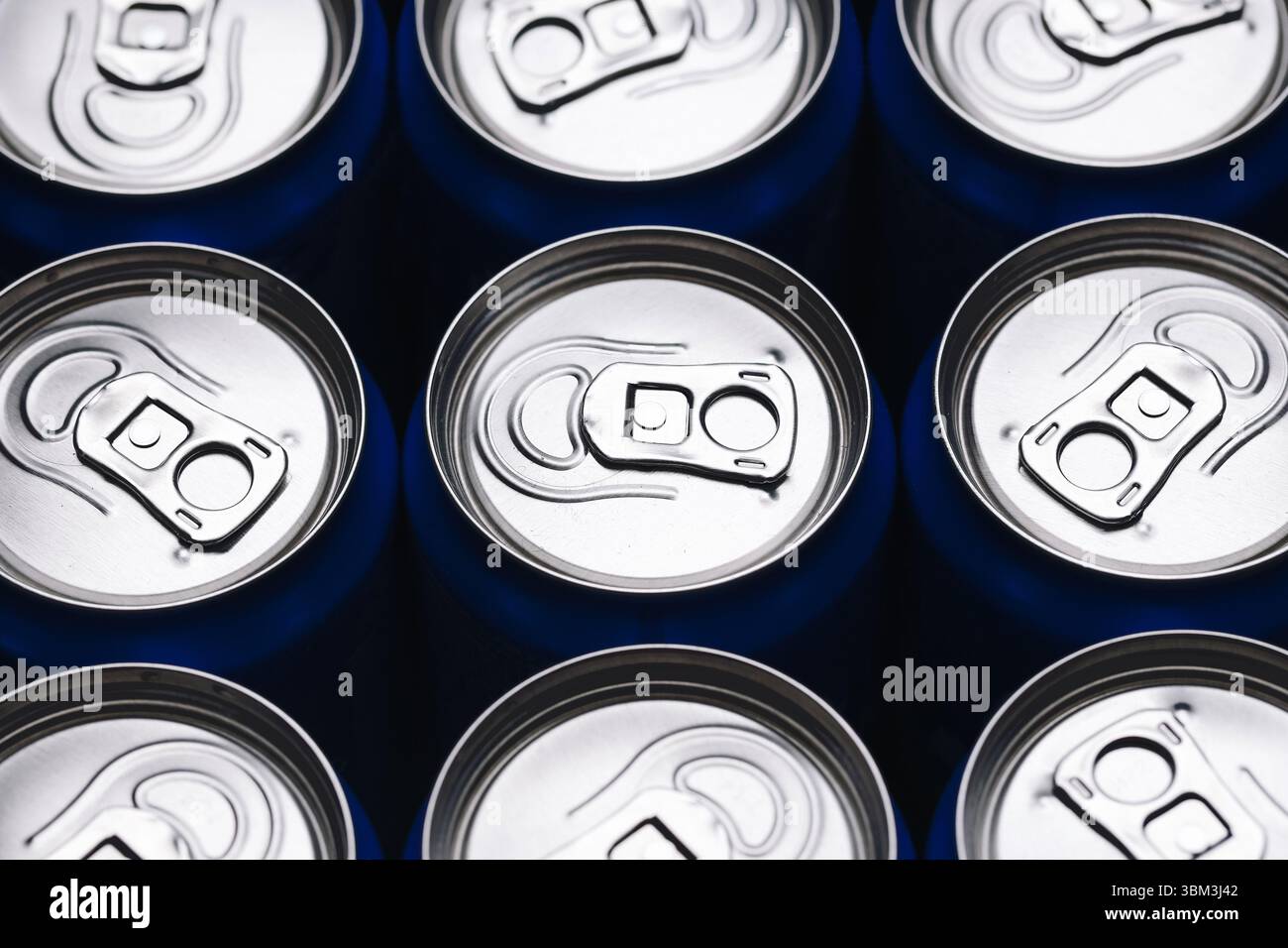 Getränkedosen aus Aluminium. Blick von oben auf silberne Soda-Dosen. Getränkeverpackung mit metallischem Glanz. Kalte Erfrischungsgetränke in Reihe. Industrieller Hintergrund. Stockfoto