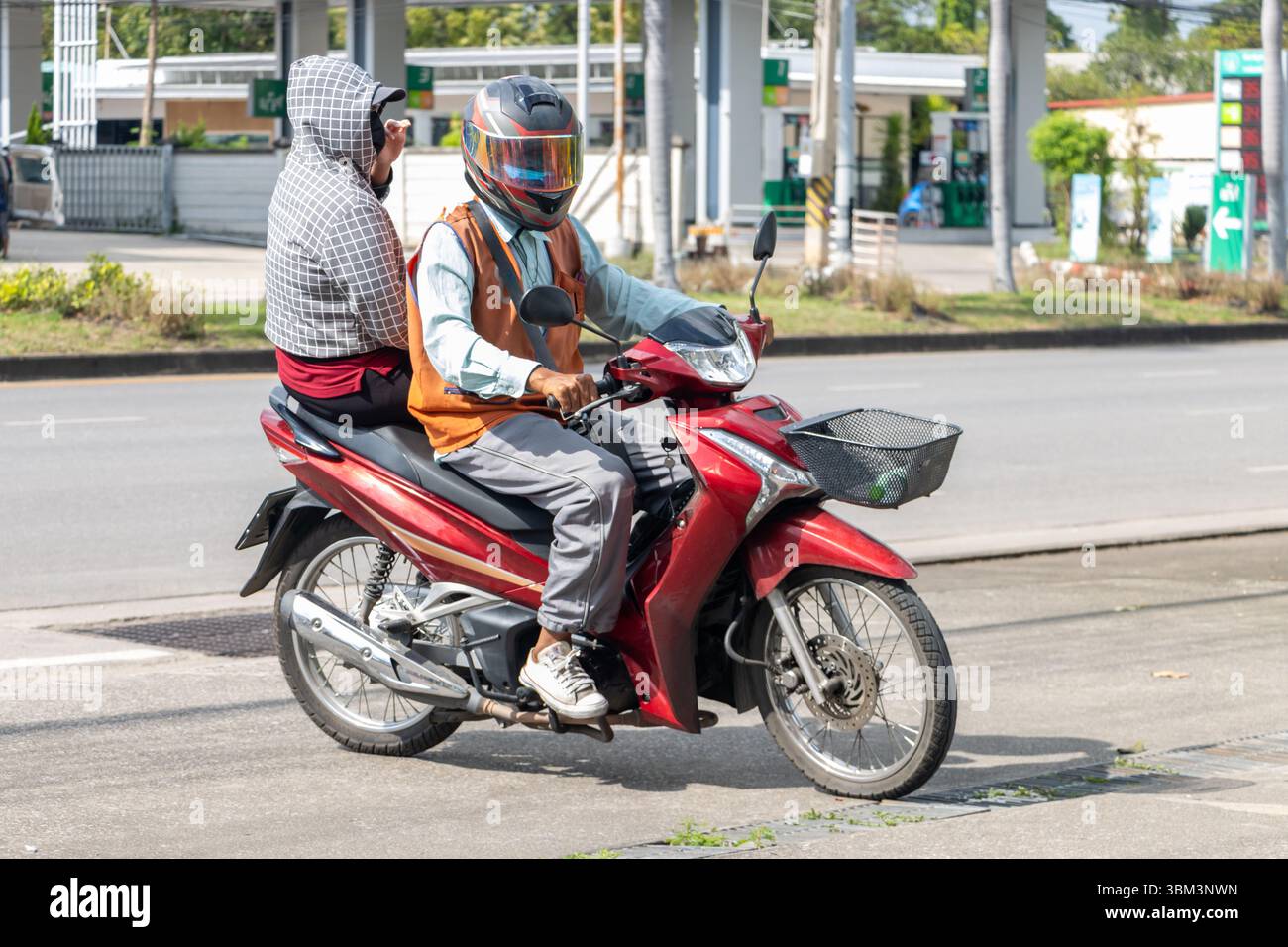 Ein Taxifahrer auf einem Motorrad fährt mit einer Frau, Thailand Stockfoto