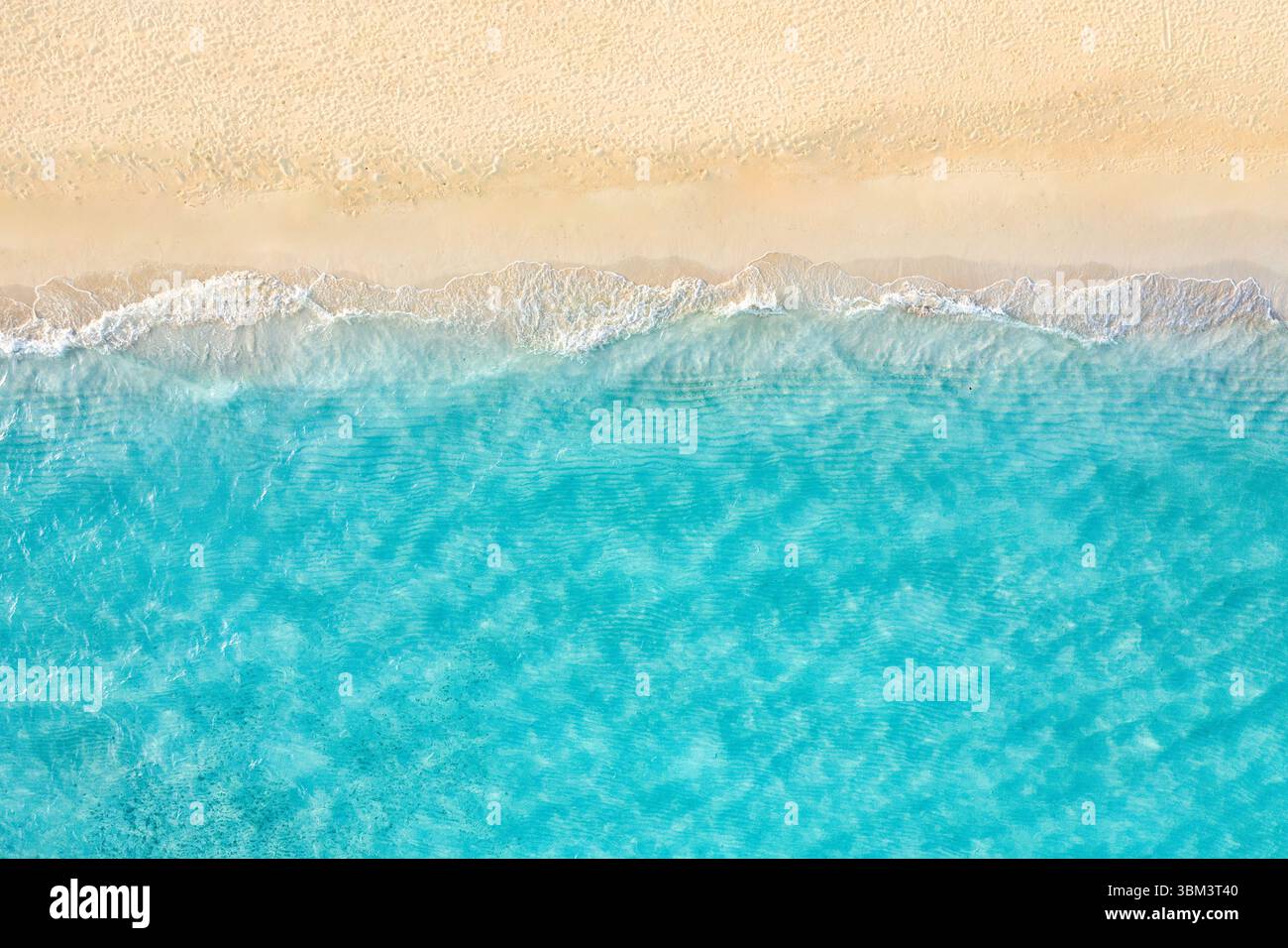 Entspannen Sie sich im Sommer aus der Luft tropischer Strand mit sanften Wellen, goldenem Sand, sonniger Küste, friedlicher, ruhiger Blick auf das Meer und die natürliche Landschaft, perfekter Urlaub Stockfoto