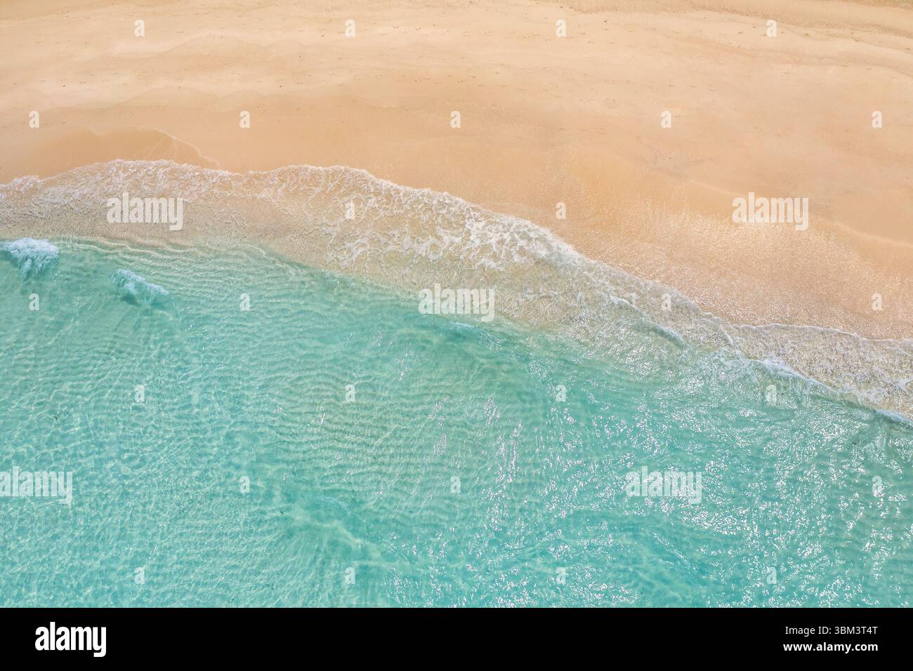 Entspannen Sie sich im Sommer aus der Luft tropischer Strand mit sanften Wellen, goldenem Sand, sonniger Küste, friedlicher, ruhiger Blick auf das Meer und die natürliche Landschaft, perfekter Urlaub Stockfoto
