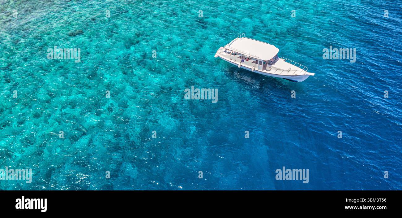 Fantastischer Blick auf das Boot aus der Vogelperspektive auf dem türkisfarbenen Meer Lagune Korallenriff, tropische Ozeanlandschaft Meeresabenteuer Natur Hintergrund Sommerreiseziel Stockfoto