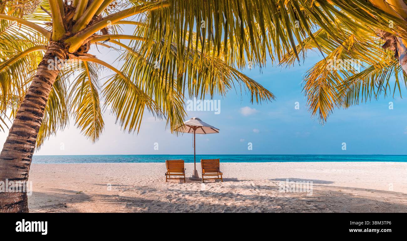 Fantastischer Sommer Panorama Strandlandschaft romantische Paar Stühle unter Sonnenschirm Palmen Luxusziel Entspannung tropische Vibes friedliche Küste Stockfoto