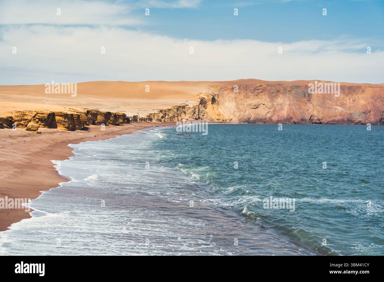 Ein atemberaubender Blick auf Playa Roja, bekannt für seinen einzigartigen roten Sand und die dramatischen Klippen im Paracas Natural Reserve. Stockfoto