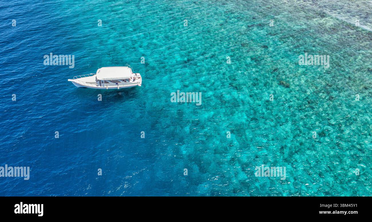 Panoramablick auf das weiße Boot Schnorcheln Tauchen in der Lagune Bucht des tropischen Ozeans auf den Malediven mit wunderschönem Korallenriff, malerischem türkisfarbenem Wasser im Sommer Stockfoto