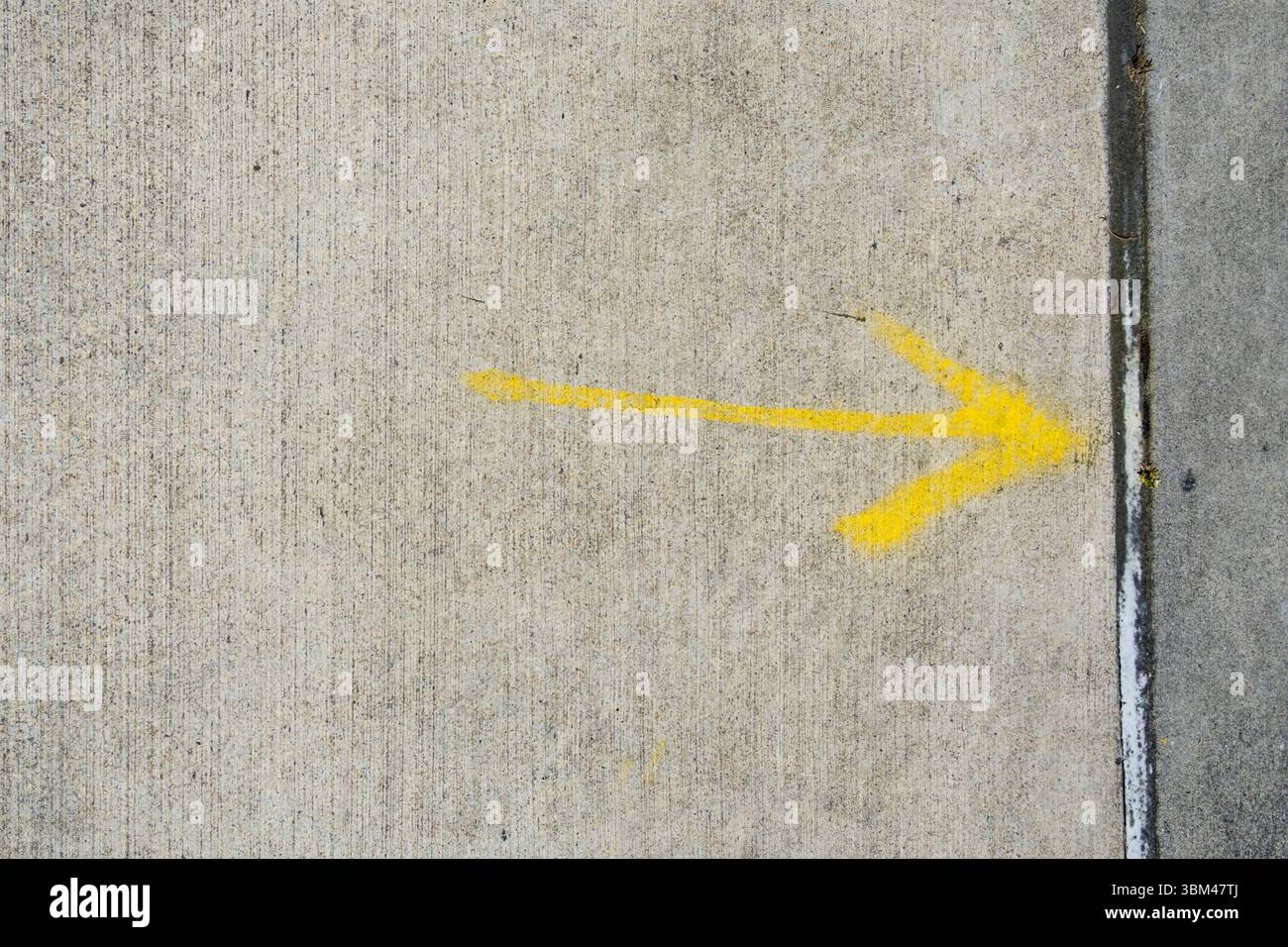 Gelber Pfeil auf Bürgersteig gemalt, USA Stockfoto