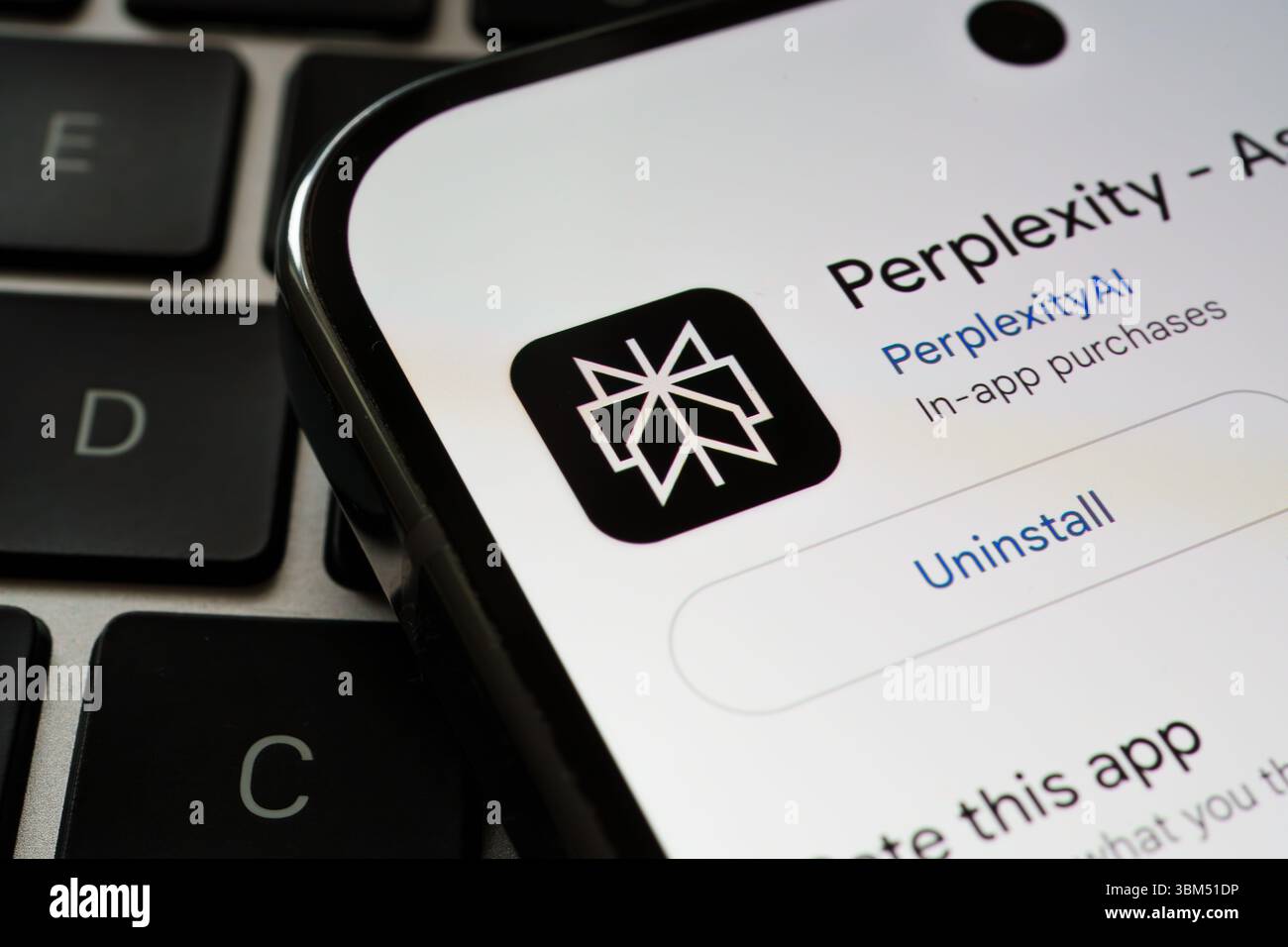 Perplexity AI-Logo und Deinstallationsoberfläche werden in Nahaufnahme auf dem mobilen Bildschirm über Laptoptasten angezeigt. Stafford, Großbritannien, 24. Juni 2025 Stockfoto