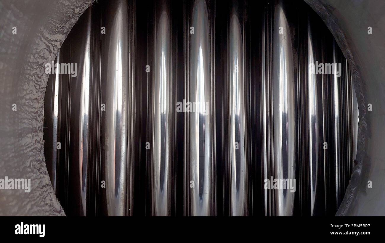 Die Nahaufnahme zeigt das polierte Innere von Stahlwärmetauscherrohren, was die Qualität der Fertigung in industriellen Anwendungen verdeutlicht Stockfoto