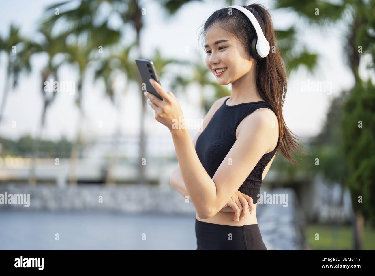 Happy Active Healthy asian Woman hört Musik mit Kopfhörern für geistige Gesundheit Hören von Audio für Laufen Inspiration Stockfoto