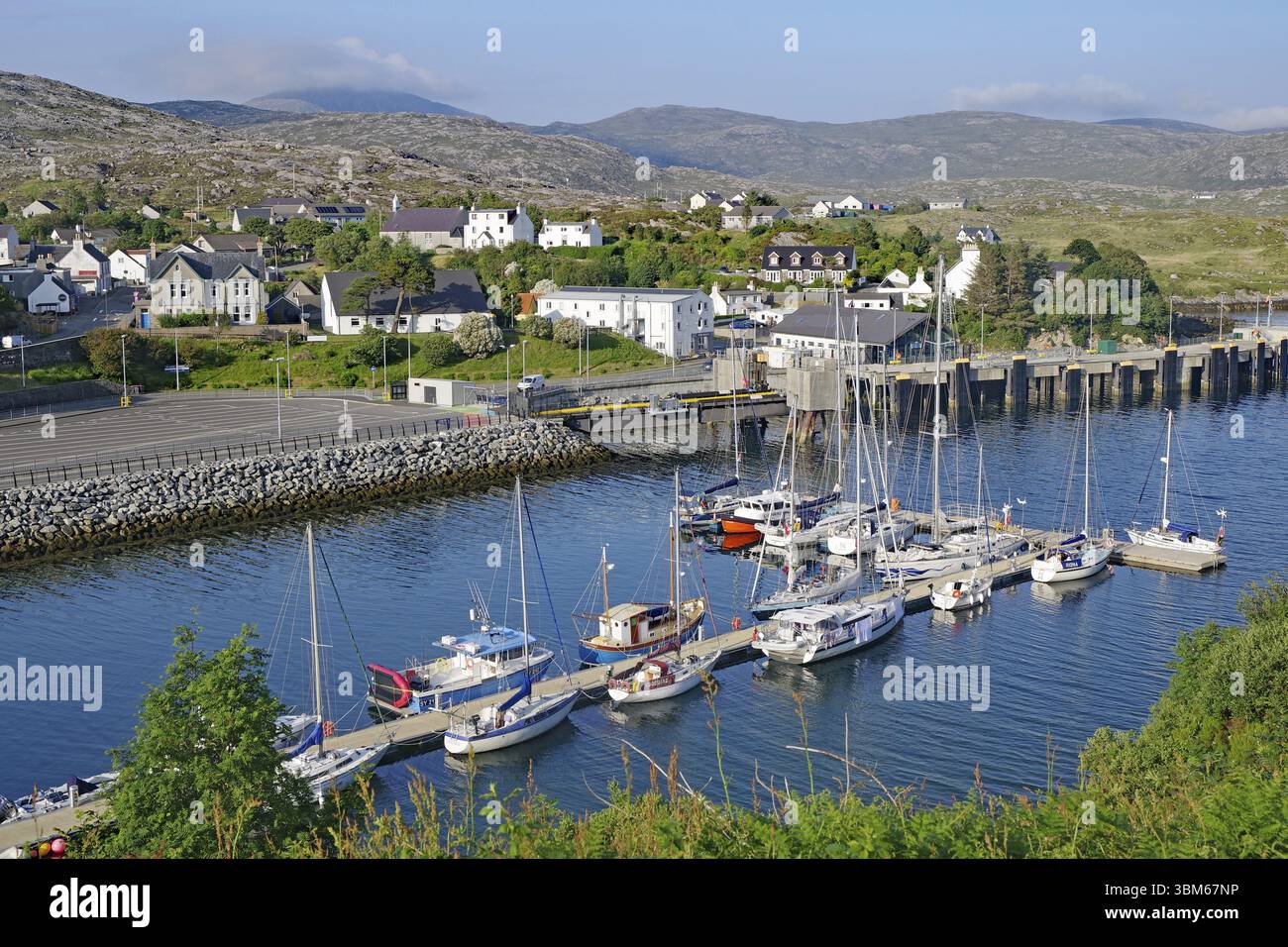Kleiner Hafen mit Segelbooten vor einer Küstenstadt in hügeliger Landschaft, Tarbert, Isle of Lewis, Hebriden, Schottland, Vereinigtes Königreich, Europa Stockfoto