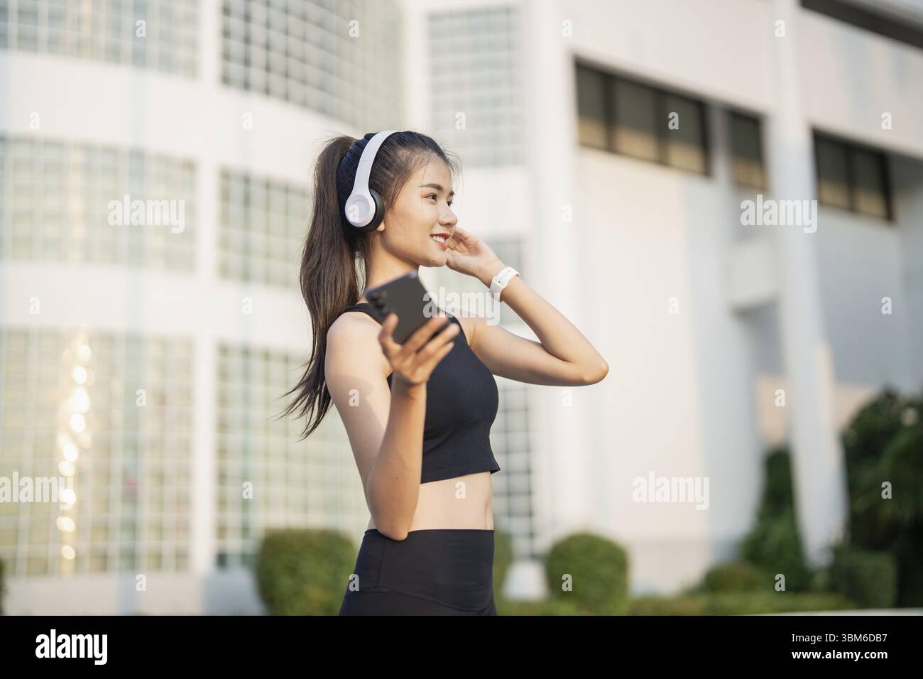 Happy Active Healthy asian Woman hört Musik mit Kopfhörern für geistige Gesundheit Hören von Audio für Laufen Inspiration Stockfoto