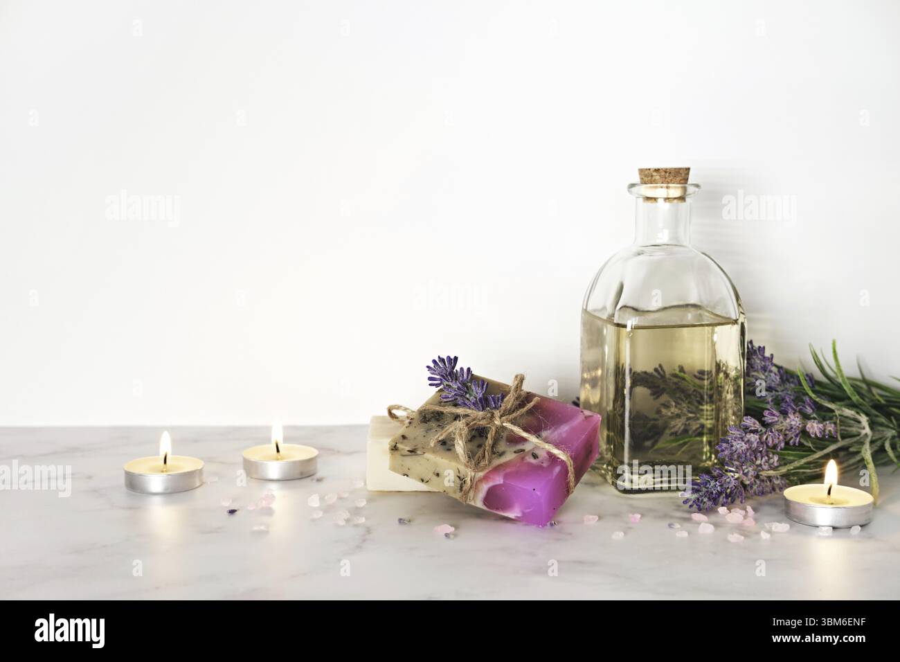 Spa-Einrichtung, Lavendelkosmetika und brennende Kerzen. Home Body Hautpflege, Spa Aromatherapie Hintergrund Stockfoto