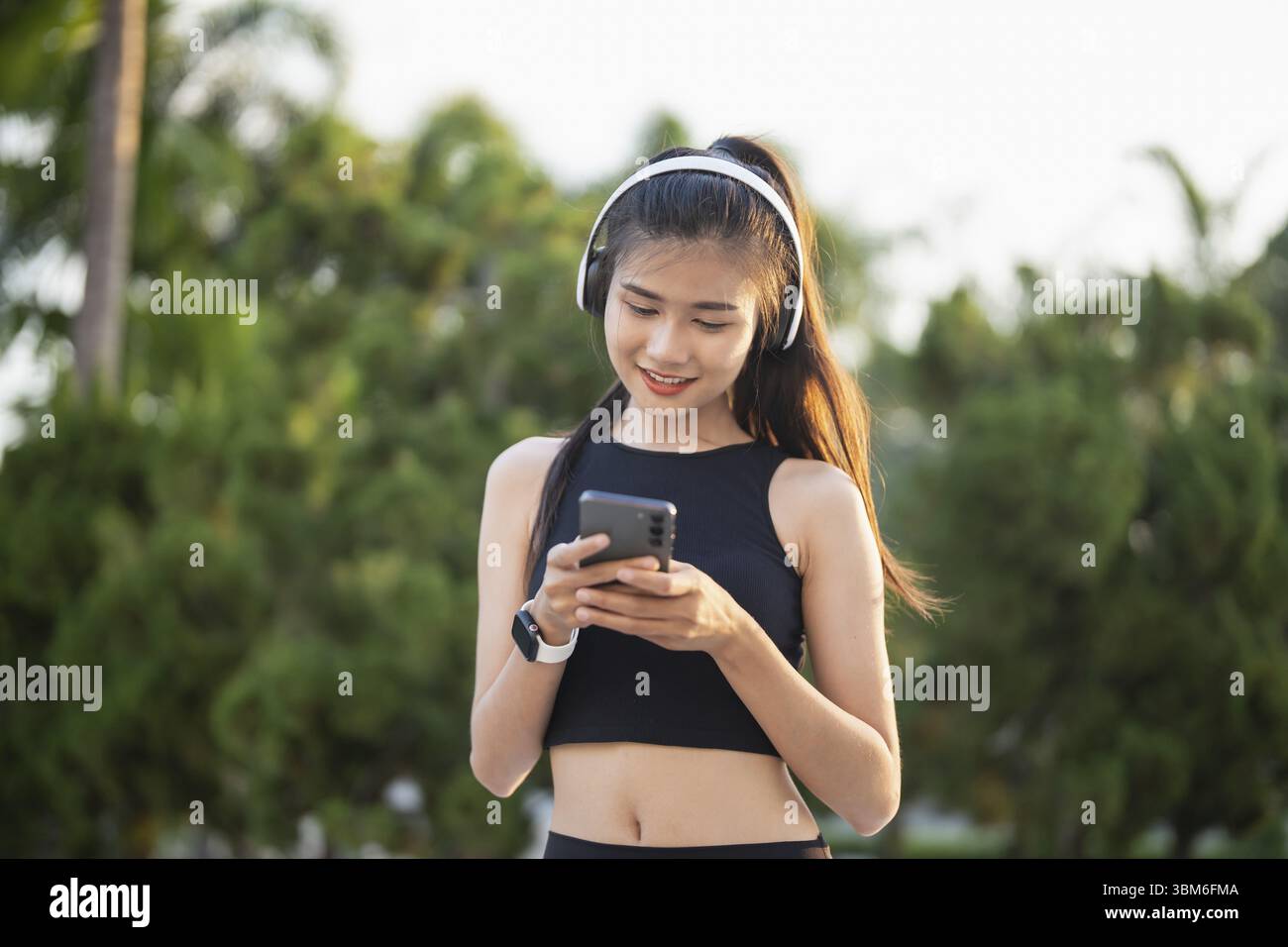 Happy Active Healthy asian Woman hört Musik mit Kopfhörern für geistige Gesundheit Hören von Audio für Laufen Inspiration Stockfoto