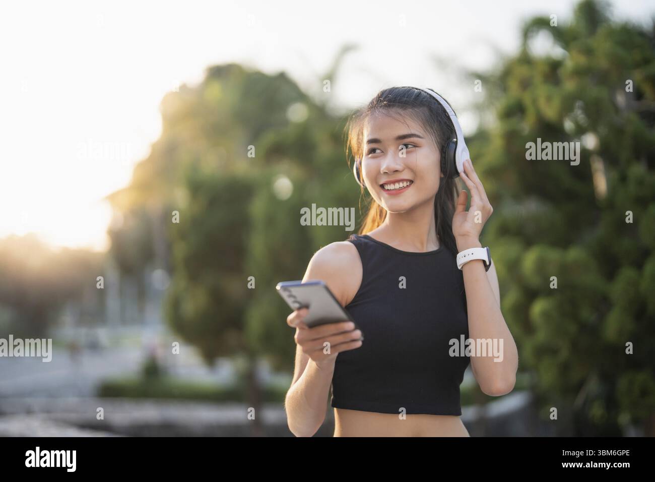 Happy Active Healthy asian Woman hört Musik mit Kopfhörern für geistige Gesundheit Hören von Audio für Laufen Inspiration Stockfoto