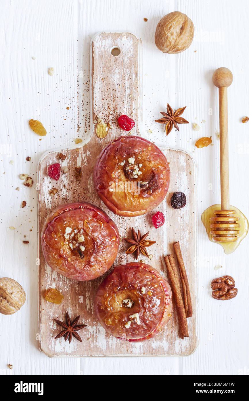 Rote gebackene Äpfel mit Zimt, Nüssen und Honig. Herbst oder Winter Dessert. Ansicht von oben Stockfoto