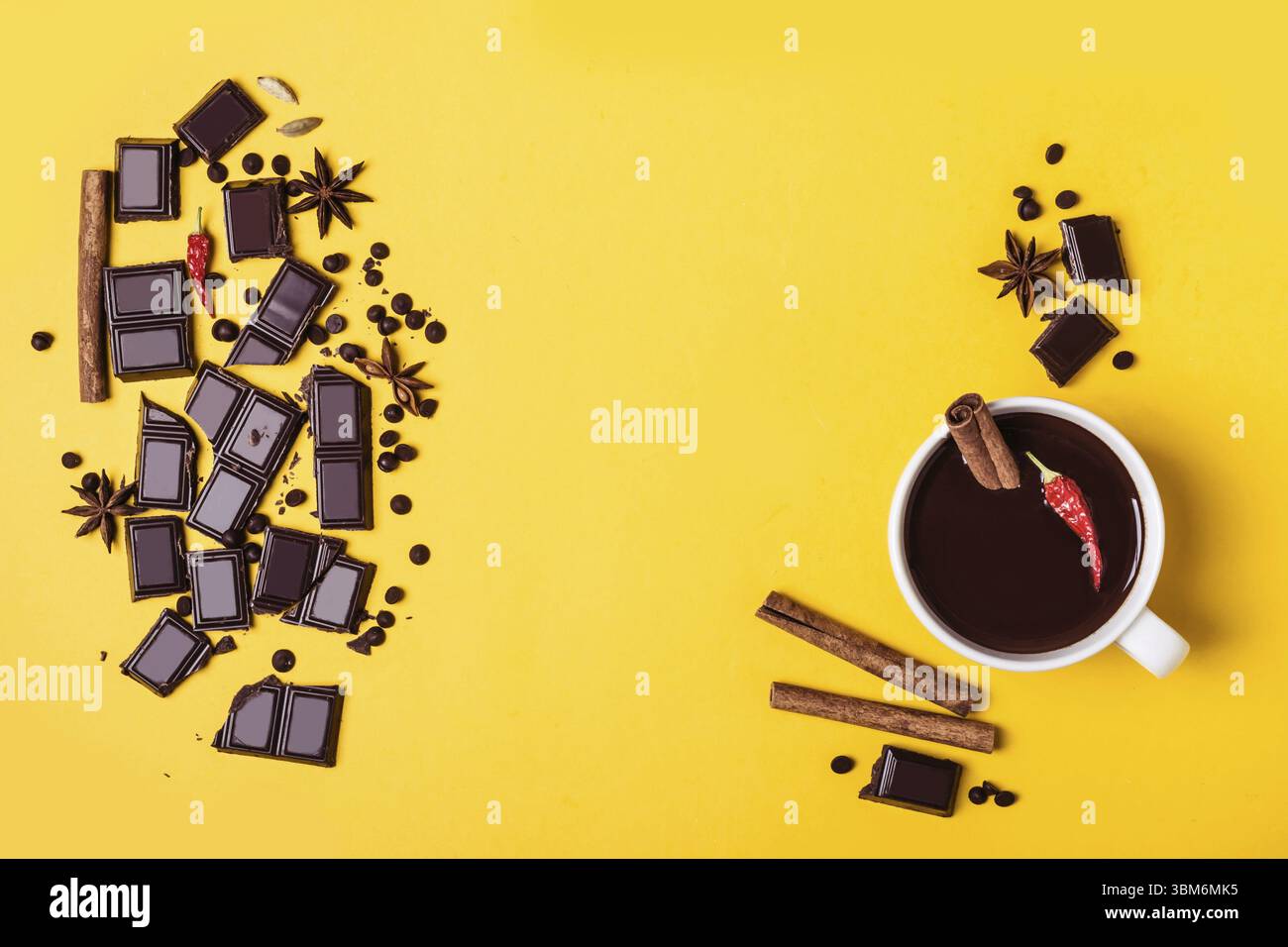 Heiße Schokoladentasse mit heißem Pfeffer und Zimt. Zutaten für das Kochen auf gelbem Hintergrund. Wärmendes Winter- oder Herbstgetränk-Konzept Stockfoto