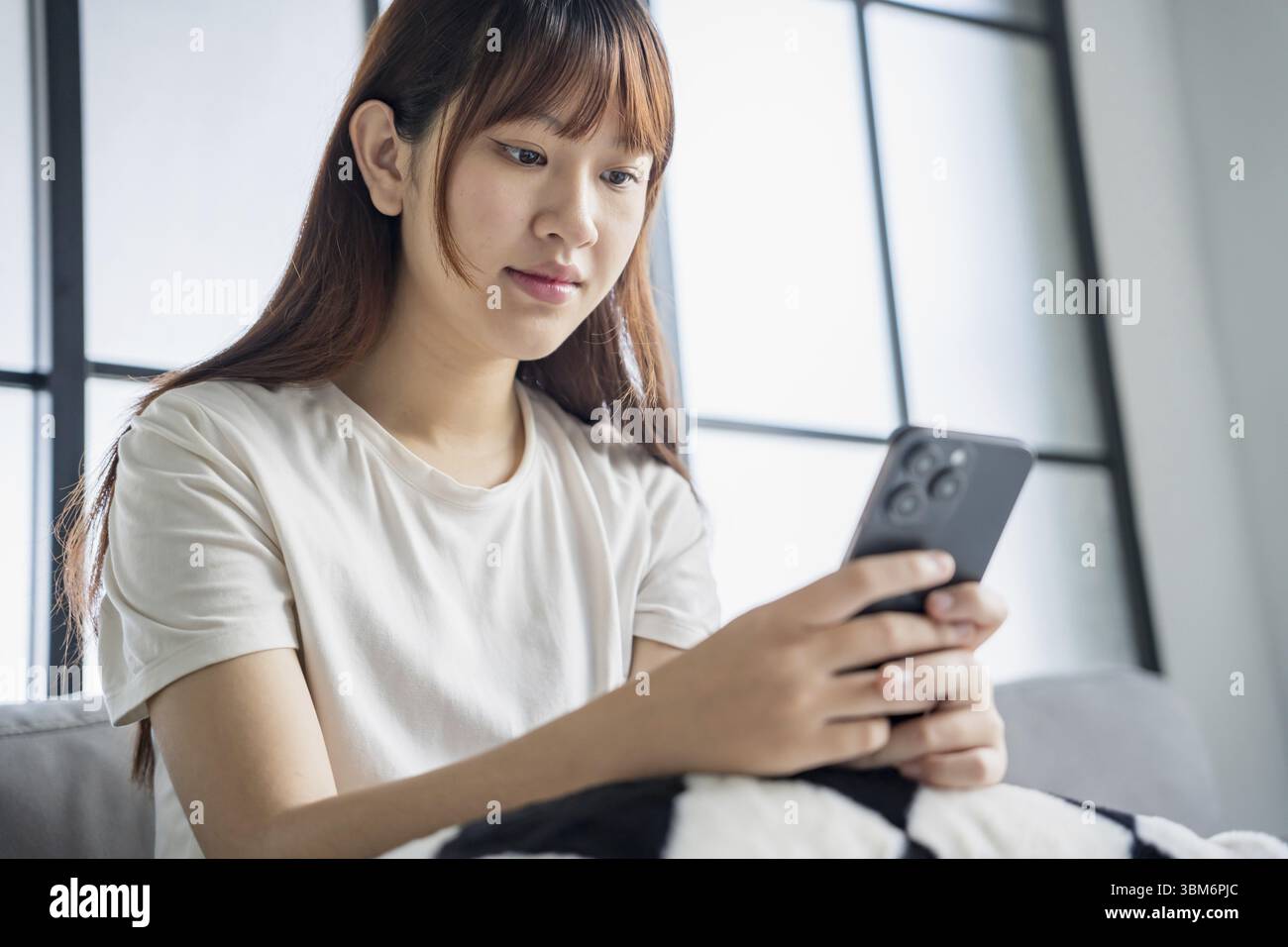 Asiatische Frau, die per Smartphone SMS Nachrichten-Browsing-Informationen verwendet Stockfoto
