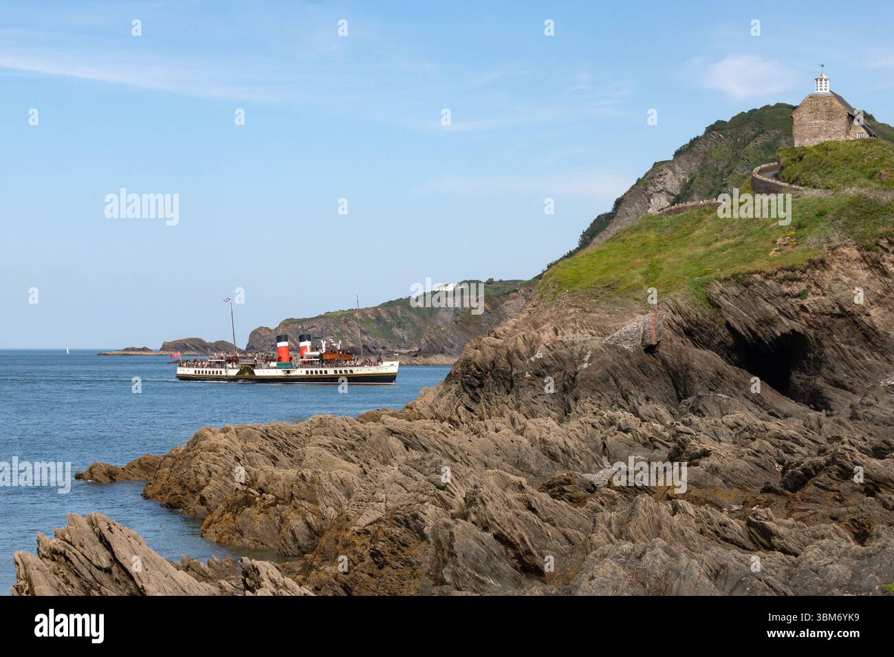 PS Waverley ist der letzte Seefahrer der Welt und führt zwischen der St. Nicholas' Chapel und den Cottages der Küstenwache in den Hafen von Ilfracombe Stockfoto