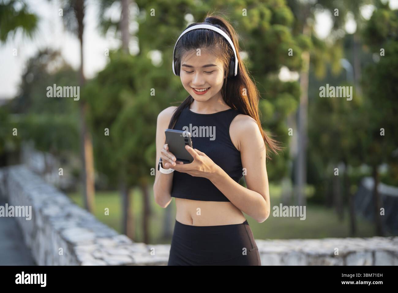 Happy Active Healthy asian Woman hört Musik mit Kopfhörern für geistige Gesundheit Hören von Audio für Laufen Inspiration Stockfoto