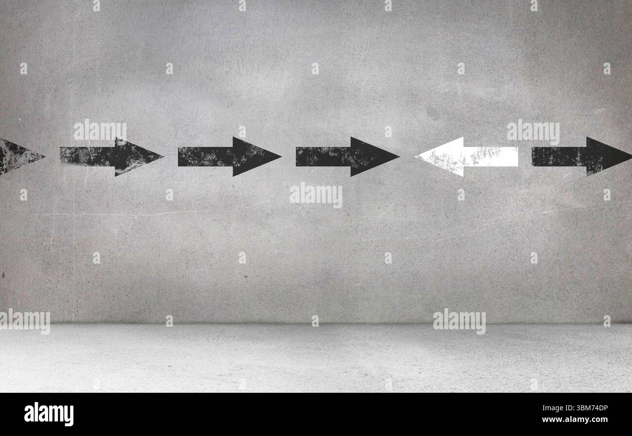 Pfeilschilder an der grauen Wand Stockfoto