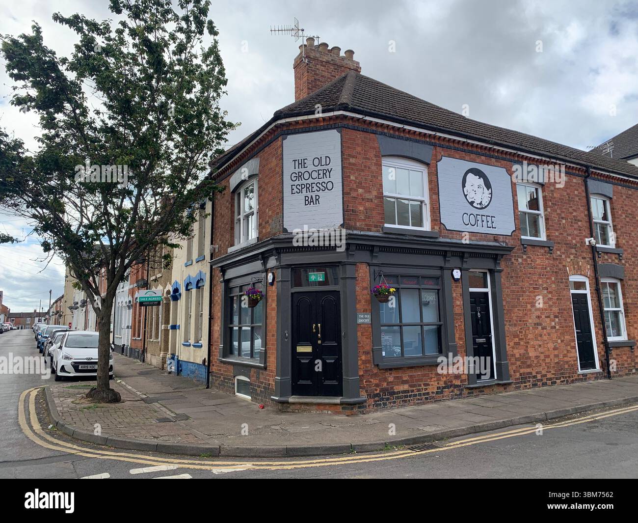 Haus in der Colwyn Road Northampton Old Shop Lebensmittelgeschäfte Shakespeare Road Baumgarten hohe hohe Büsche Plakate Plakate Studenten leben Stockfoto