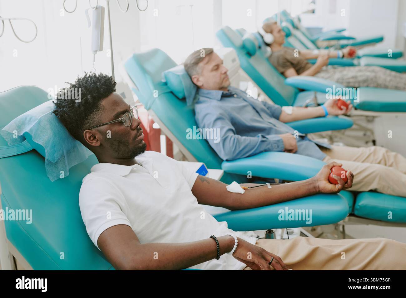 Multiethnische Männer spenden Blut in der medizinischen Klinik während der Blutspende Drive Stockfoto